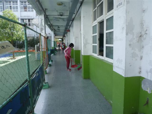 第六 棟一樓走廊上認真打掃的小朋友