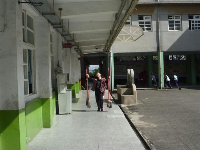 第三棟一樓走廊上認真協助打掃的老師