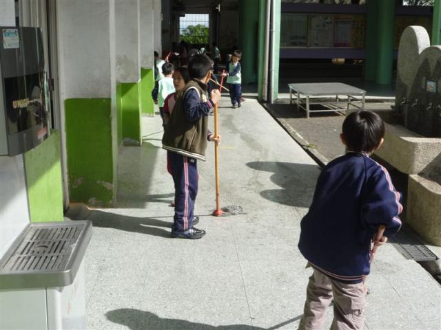 第三棟一樓走廊上認真打掃的小朋友
