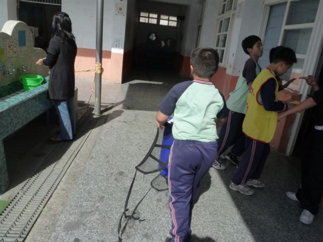 第四棟一樓走廊上認真做回收的小朋友