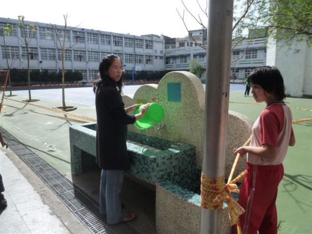 第四棟一樓走廊上認真協助打掃的老師