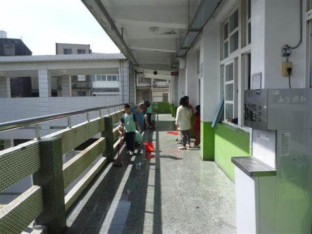 第四棟二樓走廊上認真打掃的小朋友